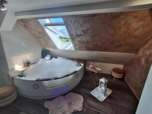 a bathroom with a large bath tub in the ceiling at Leśny zakątek in Rękusy