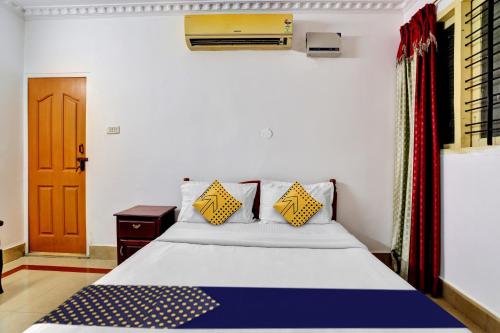 a bedroom with a bed with yellow and blue pillows at Hotel O MAJESTIC INN in Chacka