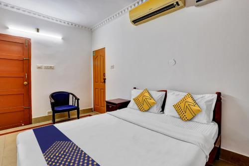 a bedroom with a bed and a blue chair at Hotel O MAJESTIC INN in Chacka