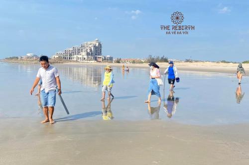 a group of people walking on the beach at The Rebirth Apartment Binh Chau Ho Tram in Ba Ria