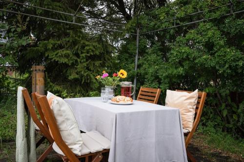 a table with a white table cloth and flowers on it at Guestly Homes - Charming 4BR Villa in central Piteå in Piteå