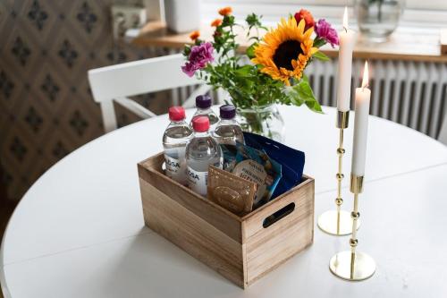 a table with a wooden crate with drinks and a vase of flowers at Guestly Homes - Charming 4BR Villa in central Piteå in Piteå