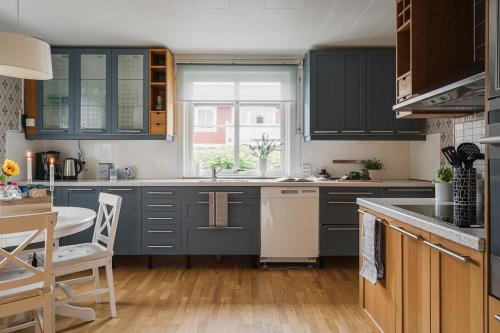 a kitchen with blue cabinets and a table and chairs at Guestly Homes - Charming 4BR Villa in central Piteå in Piteå