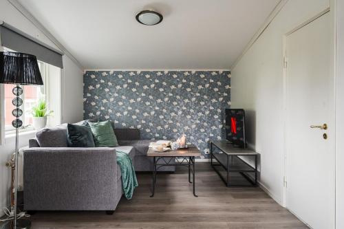 a living room with a couch and a table at Guestly Homes - Charming 4BR Villa in central Piteå in Piteå