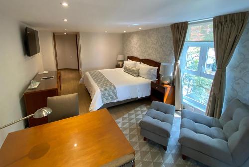 a hotel room with a bed and a table and chairs at Hotel Portón de la Cabrera in Bogotá