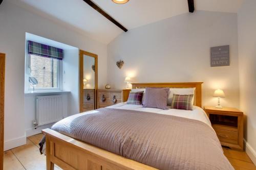 Un dormitorio con una cama grande y una ventana. en The Old Penny Bank, en Hawes