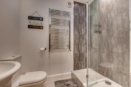 Un baño blanco con ducha y WC. en The Old Penny Bank, en Hawes