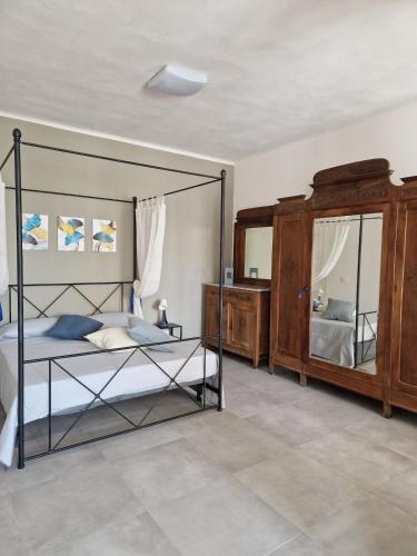 ein Schlafzimmer mit einem Himmelbett und einem Spiegel in der Unterkunft Concordia Apartment in Orta San Giulio