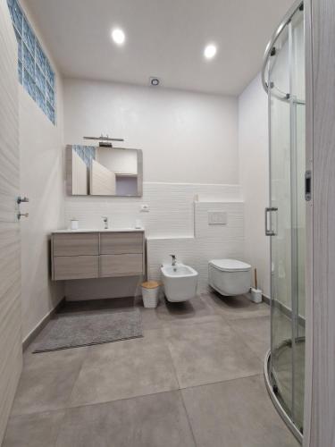 ein Badezimmer mit Waschbecken, Toilette und Dusche in der Unterkunft Concordia Apartment in Orta San Giulio