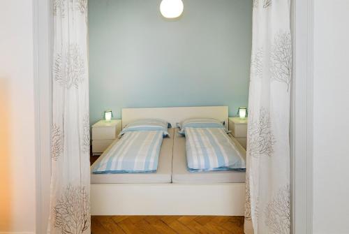 a bedroom with two beds and two curtains at Ferienwohnungen Spiegel - Fewo lue Heaven in Lindau