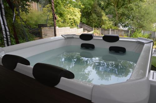 a pool table with four chairs in a backyard at Hot Tub Oasis by the Sea & Woods in Swansea