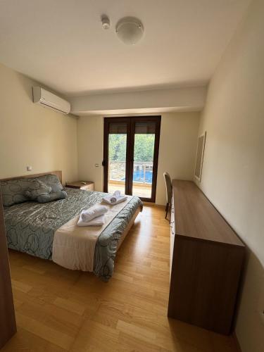 a bedroom with a bed and a wooden floor at Park Elysee Lakefront Premium Apartment in Ohrid