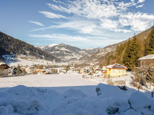 a village covered in snow with mountains in the background at Apartment Feld am See near Ski Slopes in Feld am See