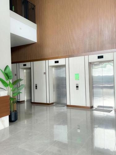 a row of elevators in a building with a potted plant at JND Residences - Sitari in Bacolod