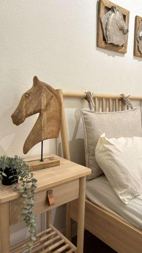 a wooden horse head on a table next to a bed at غرفة نوم مودرن بدخول ذاتي رقم سري in Tabuk