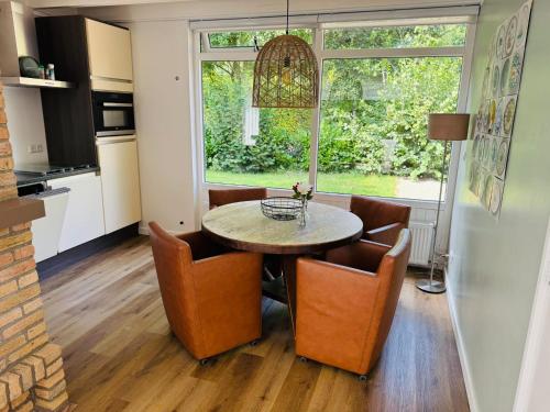 a kitchen and dining room with a table and chairs at Bungalow De Hazelaar I 4 personen - Vakantiepark De Kremmer in Gasselte