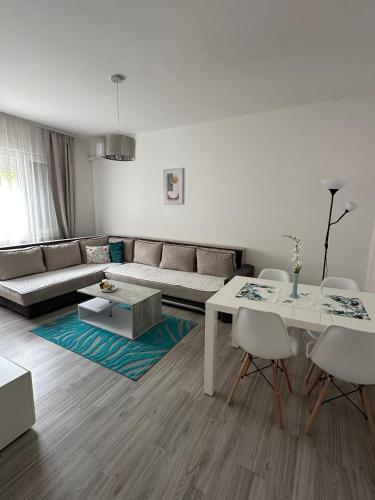 a living room with a couch and a table and chairs at Mareli in Mostar