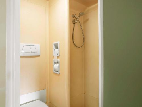 a small bathroom with a shower and a toilet at B&B HOTEL Flensburg-City in Flensburg