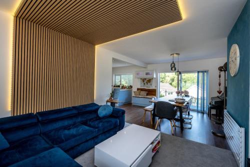 a living room with a blue couch and a table at Hot Tub Oasis by the Sea & Woods in Swansea