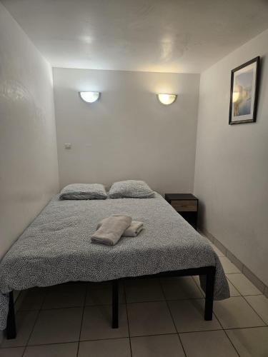 a bed in a bedroom with two towels on it at Appartement de la Pyramide in Alençon
