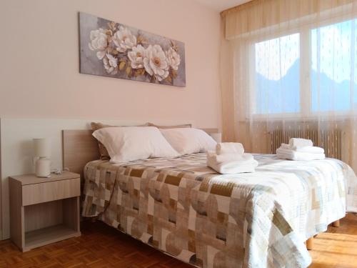 a bedroom with a bed with towels on it at Torre 2 in Longarone