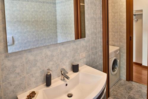 een badkamer met een wastafel en een wasmachine bij La chiave di Volta in Como