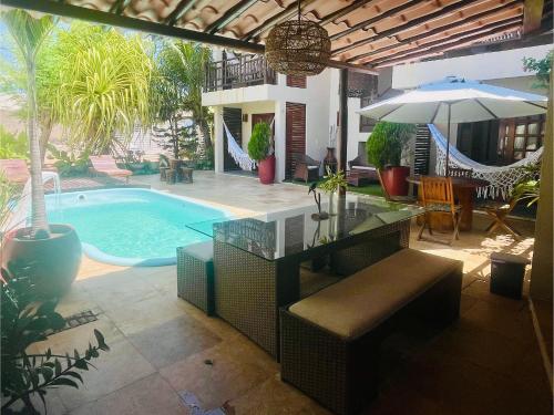 a patio with a swimming pool and an umbrella at Recanto Maria Flor by Holiday Stays in Flecheiras