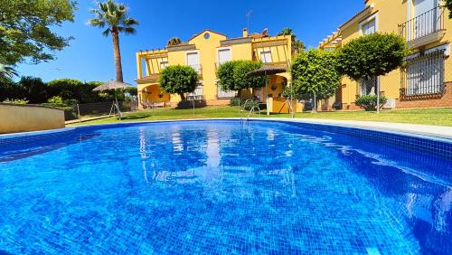 a swimming pool in front of a house at Pantoque Sani Ideal para familias in El Puerto de Santa María
