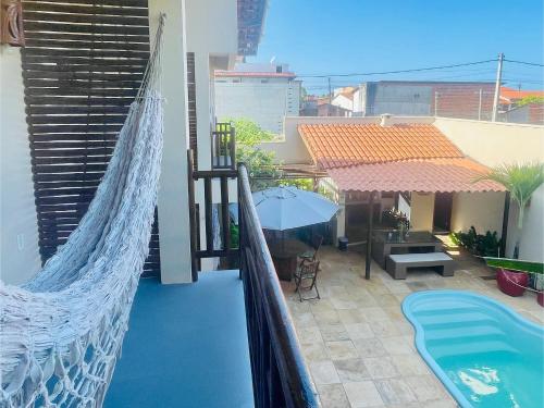 a balcony with a hammock and a swimming pool at Recanto Maria Flor by Holiday Stays in Flecheiras
