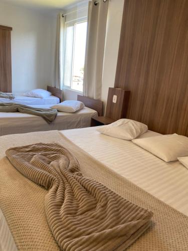 a room with three beds with a blanket on them at Hotel LENA in São Luiz Gonzaga