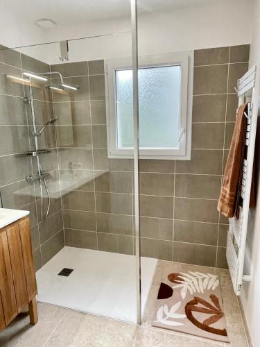 a shower with a glass door in a bathroom at Maison climatisée 3 chambres avec jardin in Pontenx-les-Forges