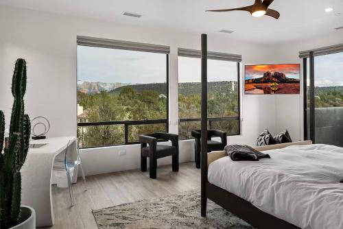 a bedroom with a bed and a desk and windows at Sedona Epic Dream 5BR Pool & Spa Rooftop in Sedona