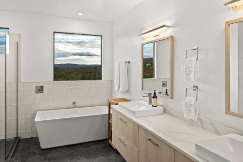 a white bathroom with two sinks and a tub and a window at Sedona Epic Dream 5BR Pool & Spa Rooftop in Sedona