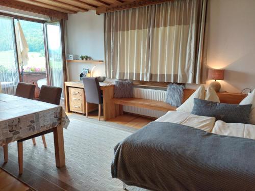 a bedroom with two beds and a desk and a table at Apartment am Wolfgangsee in Strobl