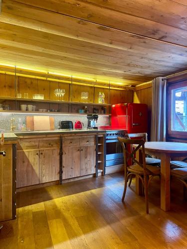 a kitchen with wooden cabinets and a table in a room at Marmotte Mountain Manor in Chamonix-Mont-Blanc