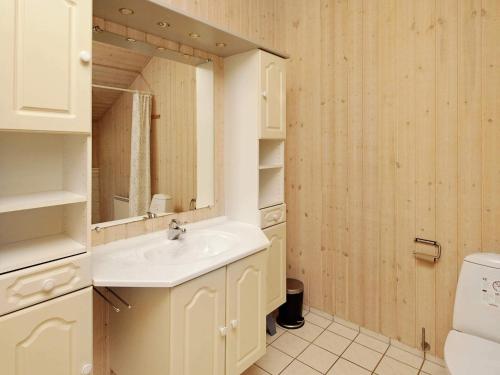a bathroom with a sink and a mirror at Lakeview Retreat with Spa - By Traum Ferienwohnungen in Ansager