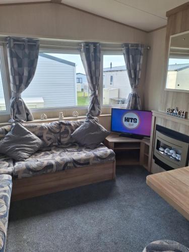 a room with a bed and a tv and a window at Caravan at the seaside in Great Yarmouth