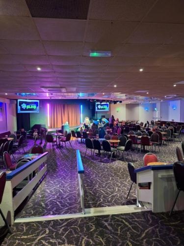 a banquet hall with people sitting in chairs in a room at Caravan at the seaside in Great Yarmouth
