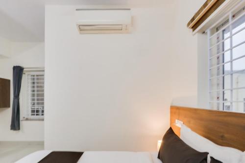 a bedroom with a bed and a window at Super Townhouse Sri Nirvana Grand in Hyderabad