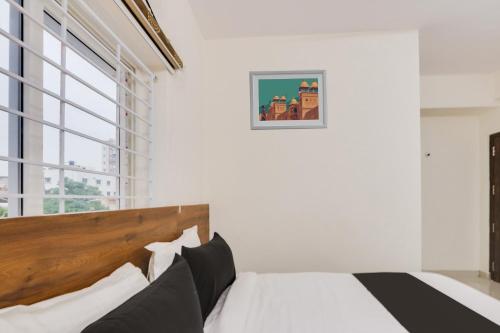 a bedroom with a bed and a large window at Super Townhouse Sri Nirvana Grand in Hyderabad