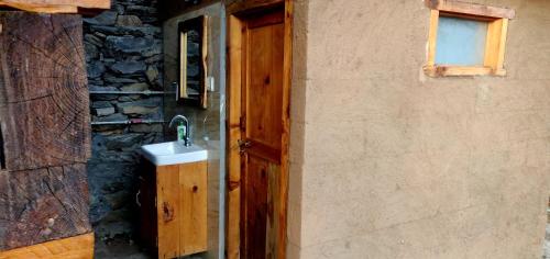 a wooden door with a sink next to a building at Parvatis Lap Luxury Hostel & Camps in Kasol