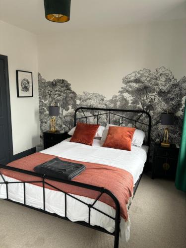 a bedroom with a large bed with red pillows at Basin Road 2 Bed House in Chichester