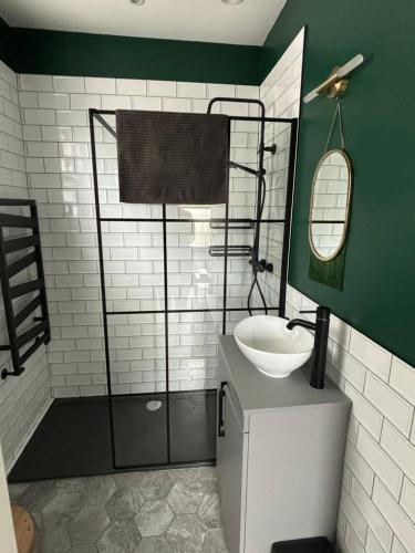 a bathroom with a shower with a sink and a mirror at Basin Road 2 Bed House in Chichester