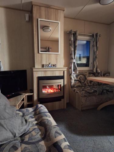 a living room with a fireplace and a tv at Caravan at the seaside in Great Yarmouth