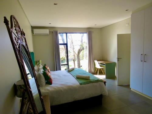 a bedroom with a bed and a large window at The Executive - Exclusive Self-Catering Apartments - Ezulwini in Ezulwini
