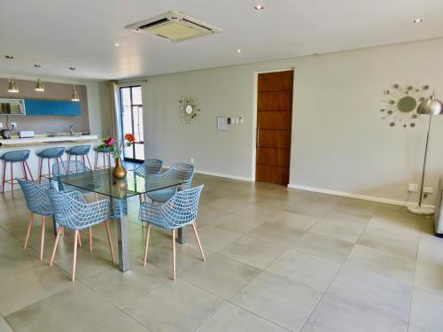 a dining room and kitchen with a glass table and chairs at The Executive - Exclusive Self-Catering Apartments - Ezulwini in Ezulwini