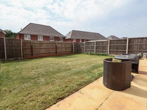 a backyard with a fence and a yard with a trash can at 29 Ernest Dawes Avenue in Telford