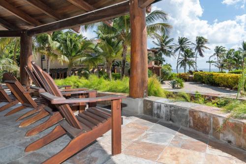 two chairs and a table on a patio with the ocean at Seascape Villas in San Pedro