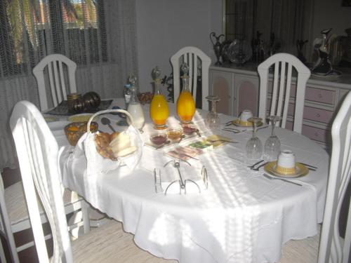 a white table with a white table cloth and food on it at Casa Teresinha in Sesimbra