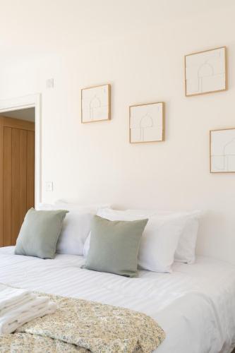 a white bed with four frames on the wall at Stylish 2-Bedroom Stay with All Comforts of Home # 2 in Rothley